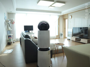 거실에서 바람을 멀리 보내는 클린부스터를사용 중인 LG 퓨리케어 AS305DWWA 공기청정기 전체 설치 모습