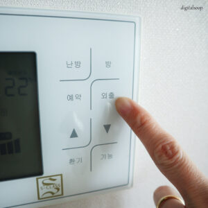 가스비 절약을 위해 보일러 설정의 외출 모드를 누르는 모습