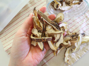 손바닥 위에 올려진 싱싱하고 상태 좋은 말린 표고버섯 슬라이스